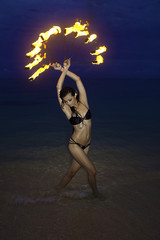 woman with fire on the beach at night