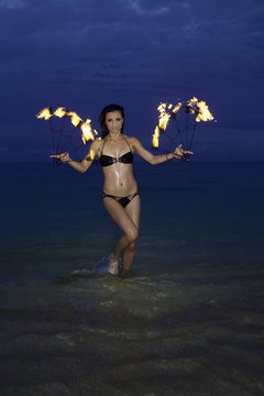 woman with fire on the beach at night