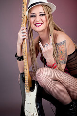 Obraz premium beautiful punk girl with lots of tattoos posing with guitar