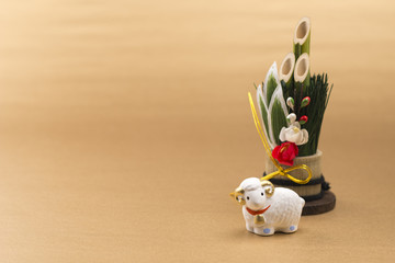 金色の背景に門松と羊の干支置物