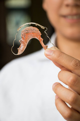 Dentist holding retainer for teeth