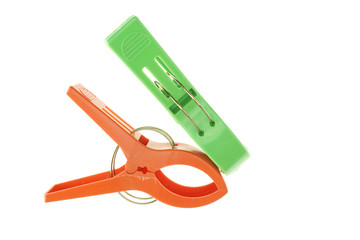 Big green and orange clothes pegs isolated
