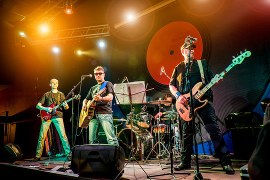 Band performs on stage in a nightclub - Powered by Adobe