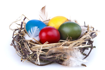 Colourful Easter eggs in a nest on white background