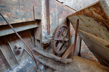 The gear wheel of a rusty old machine in brick factory