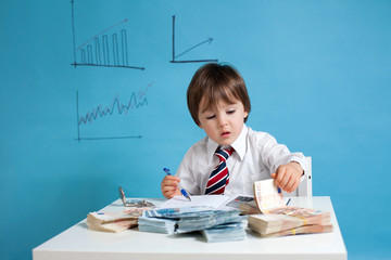 Young boy, counting money and taking notes