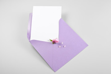 Blank greeting card in envelope with spring flowers