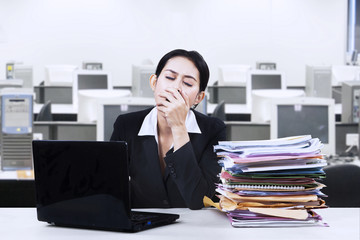 Naklejka premium Exhausted businesswoman yawning at office