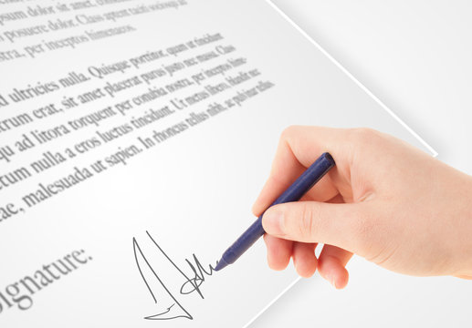 Hand writing personal signature on a paper form