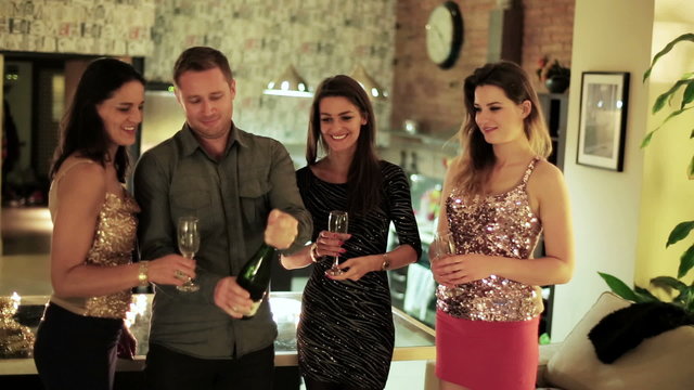 man opening the bottle of champagne and pouring into women's gla