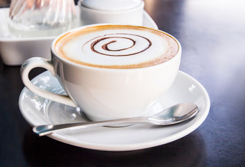 Coffee cup and saucer on black table