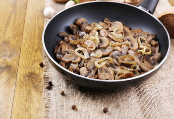 Delicious fried mushrooms in pan on table close-up