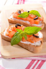 Delicious bruschetta with tomatoes on cutting board close-up