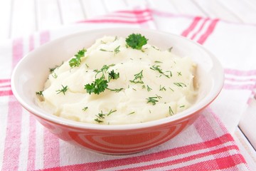 Delicious mashed potatoes with greens in bowl on table close-up