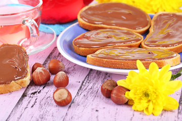 Bread with sweet chocolate hazelnut spread on plate on table