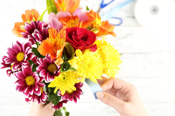 Female hands composing beautiful bouquet, close-up. Florist at