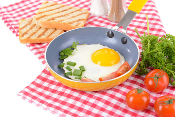 Scrambled eggs and bacon on frying pan on table close-up