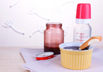 Baby food and milk on table on light background