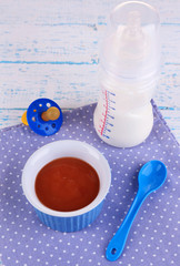 Baby food and milk on wooden table