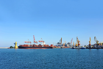 Fototapeta premium Container stack and ship under crane bridge