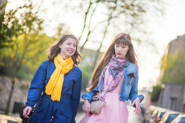Two beautiful girls walking together and chatting