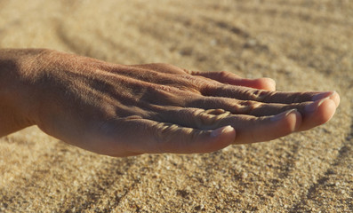 Woman hand and sand.
