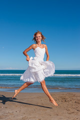 Young woman in white dress on the beach