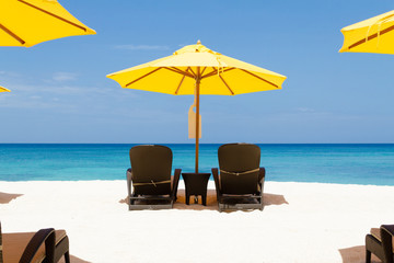 Yellow sun umbrellas and chairs on beach