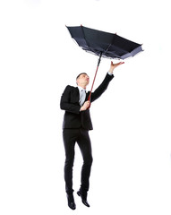 Businessman with umbrella fighting with strong wind