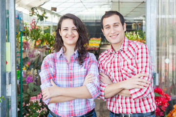 Nursery Owners with Greenhouse on Background