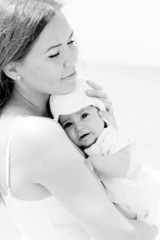 Portrait of happy loving mother and her baby at the beach