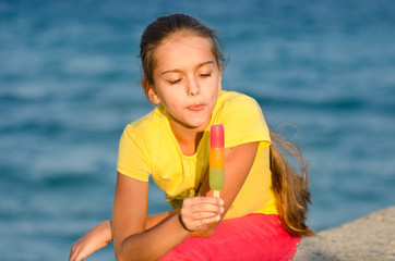 Girl licking ice cream, portrait of girl with colored dessert