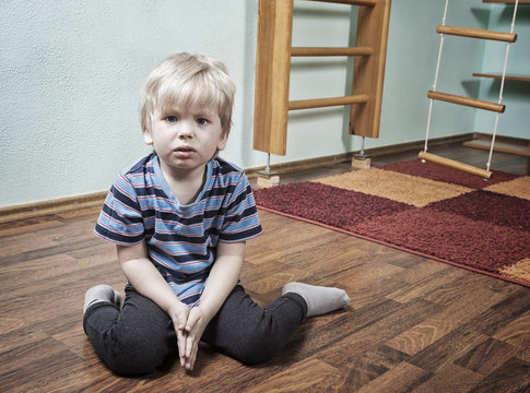 Sad boy in children room