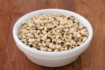 beans in white bowl on brown background