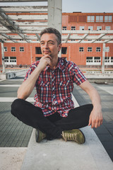 Man in short sleeve shirt sitting outdoor