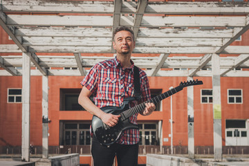 Man in short sleeve shirt playing electric guitar