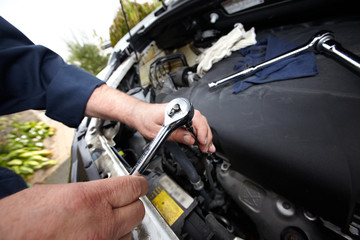 Fototapeta premium Hands of auto mechanic with wrench.