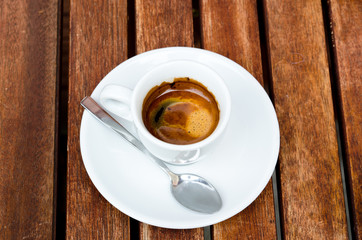 White espresso cup standing on the wooden table