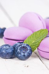 macaroons fresh blueberries on white wooden background