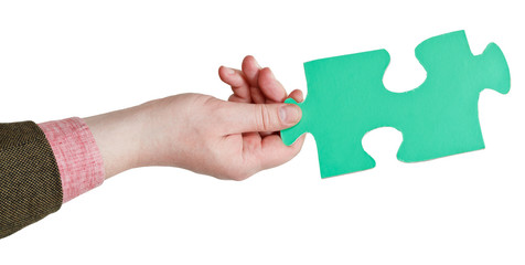 male hand holding big green paper puzzle piece