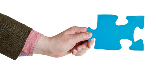 male hand holding big blue paper puzzle piece