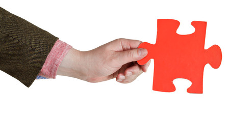 male hand holding big red paper puzzle piece