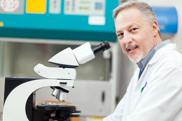 Scientist conducting research looking through microscope