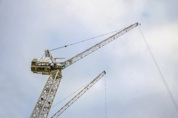 Fototapeta na wymiar Construction crane lifting load at building site