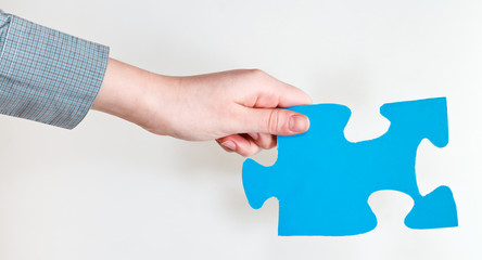 blue puzzle piece in female hand