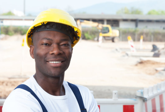 Friendly laughing african worker at construction zone