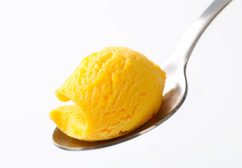 Yellow ice cream on a spoon