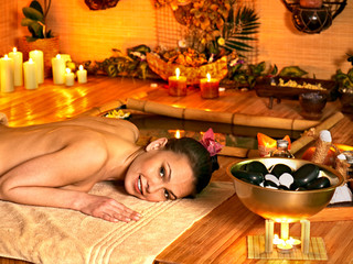 Woman getting stone therapy massage .