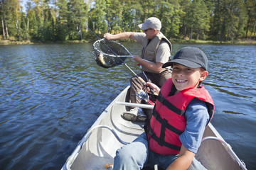 Young boy fisherman smiles at catch of nice walleye