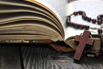 Rosary and old book on a wooden table